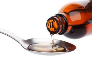 Bottle pouring Medicine Syrup in Spoon